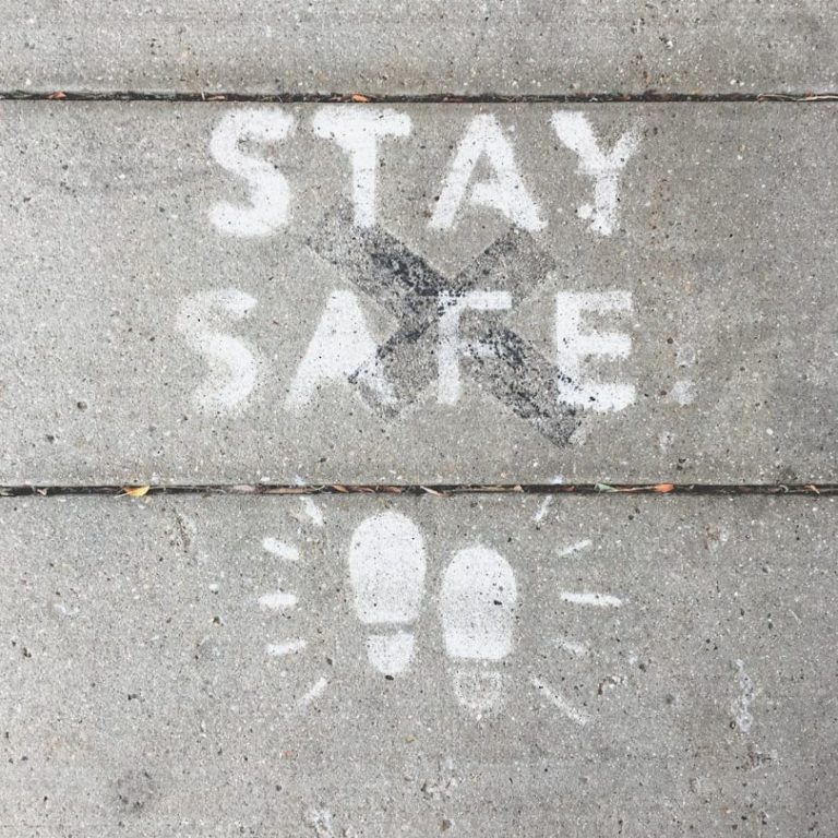 Text on pavement reads "STAY SAFE" with footprints and decorative lines.