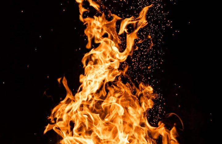 Fire Awareness (Edu) Flames dancing against a dark background, with sparks and embers rising.